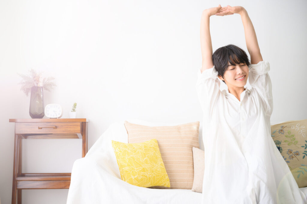 目を閉じて伸びをしている女性