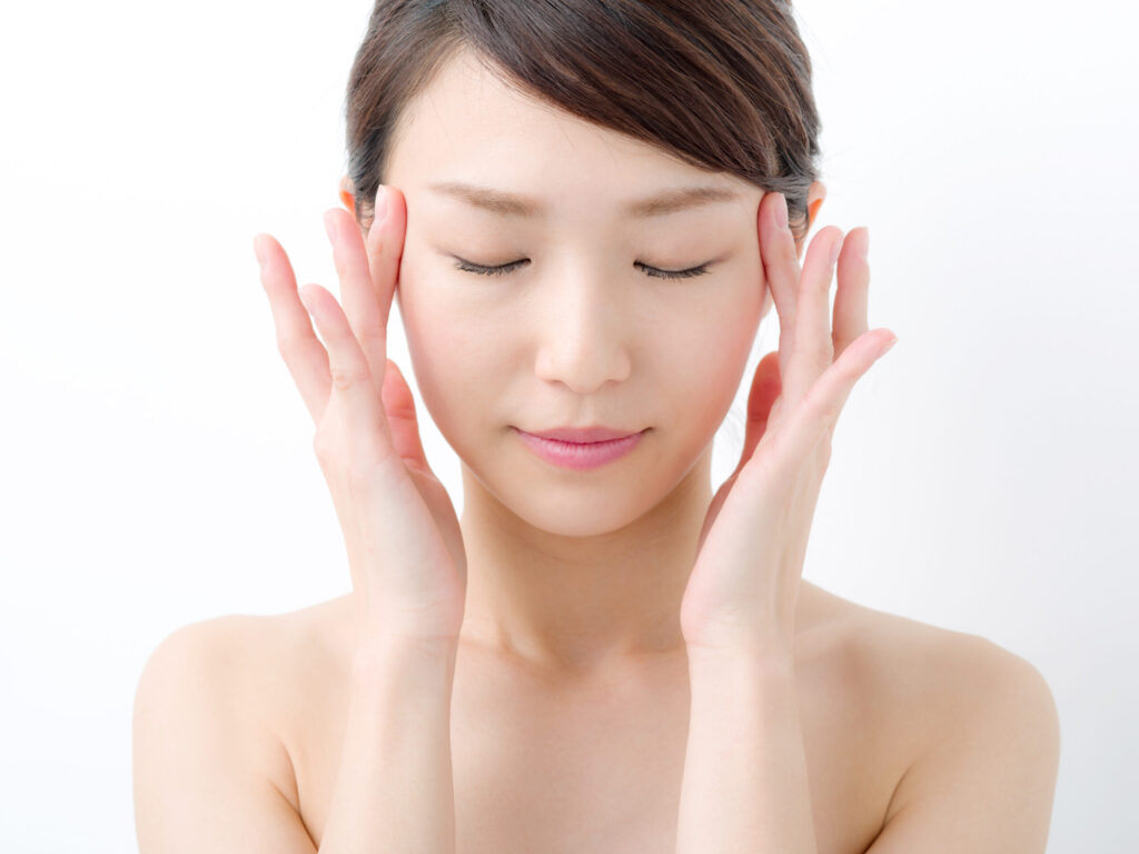 こめかみに手をあてて目を閉じている女性
